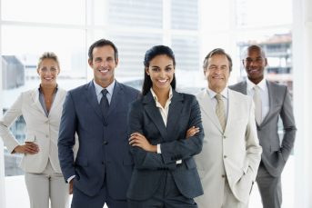 Happy confident business woman heading a team of successful colleagues